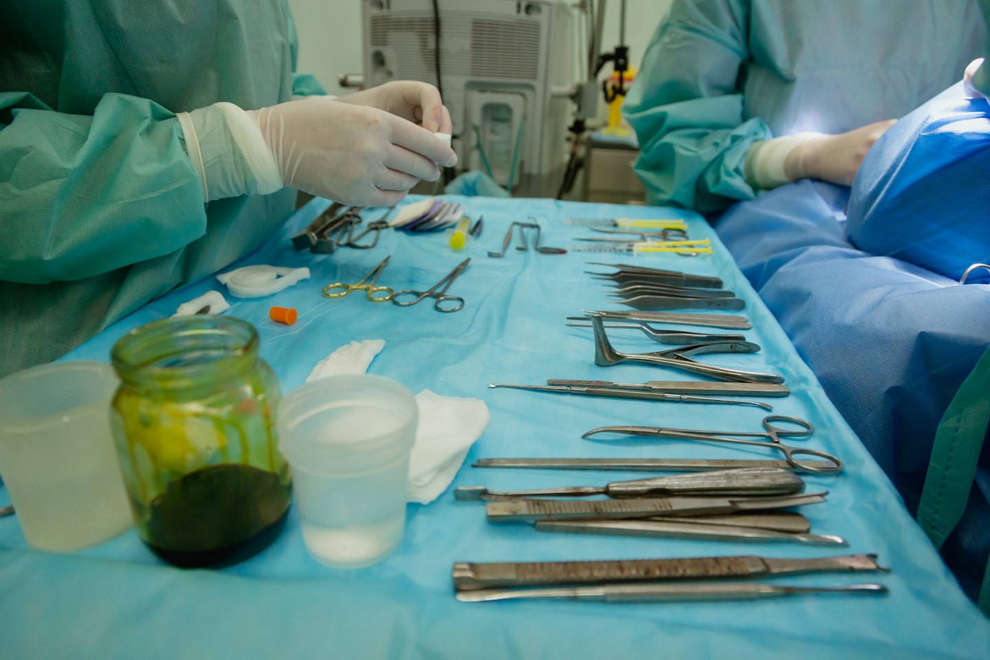 Profesional médico organizando instrumentos quirúrgicos y gasas para un procedimiento.
