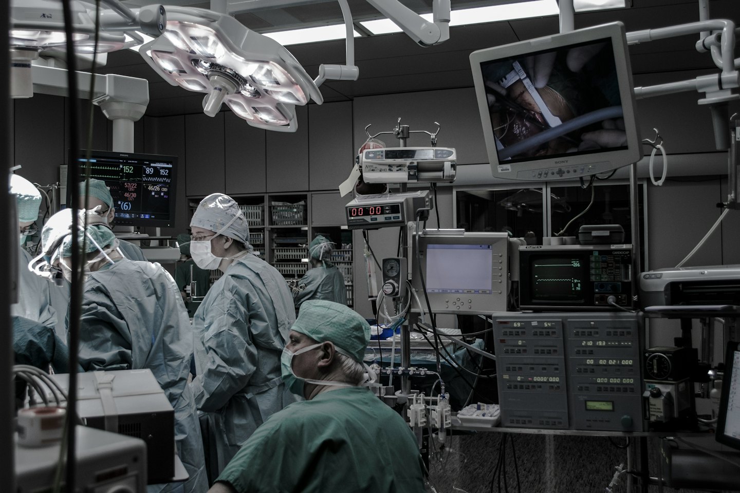 Equipo médico realizando una cirugía con monitores y equipo.